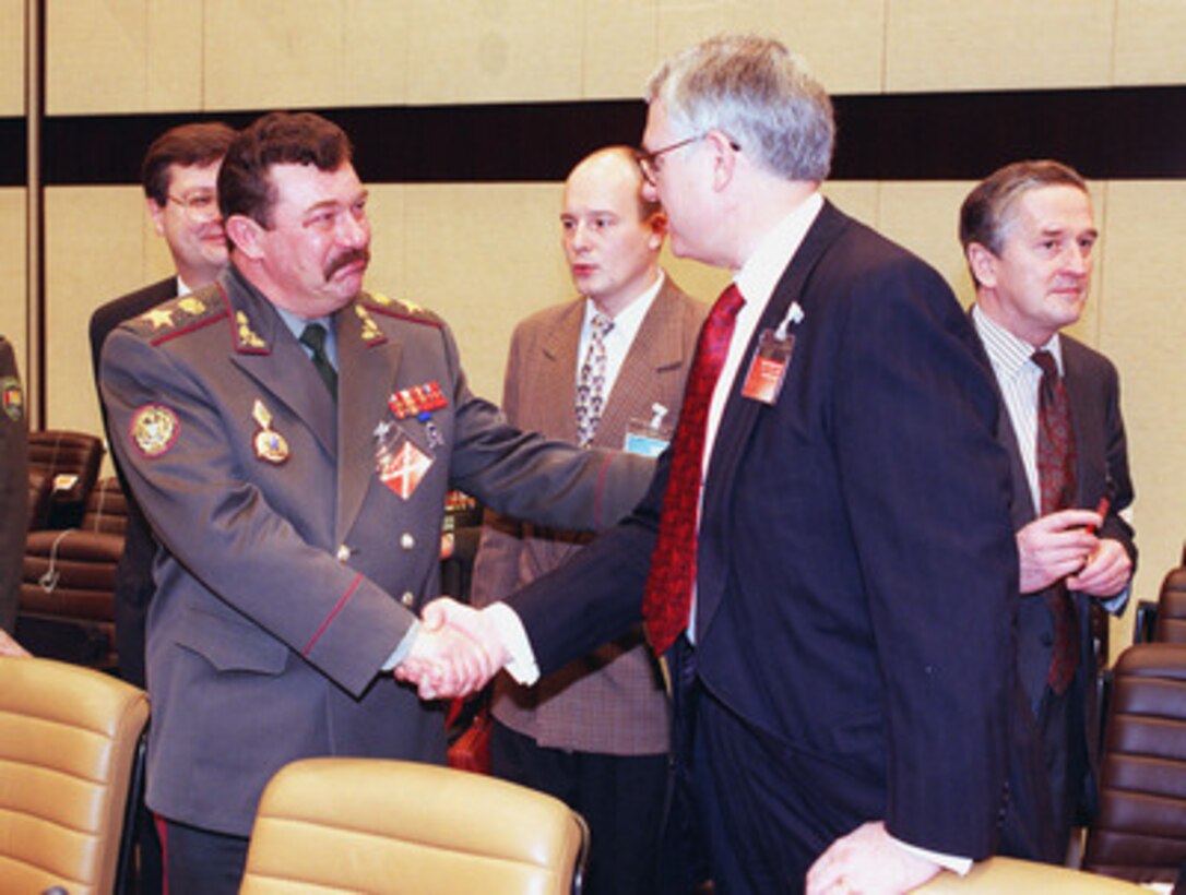 Deputy Secretary of Defense John J. Hamre (right) greets Gen.-Col. Oleksandr Kuzmuk, minister of defense of Ukraine, before the start of the Euro-Atlantic Partnership Council meeting at NATO Headquarters on Dec. 18, 1998. Hamre replaced Secretary of Defense William Cohen at the December NATO Defense Ministerial because of the start of a joint U.S.--British bombing campaign against Iraq. The military action was taken in response to Iraq's refusal to cooperate with United Nations weapons inspectors. 