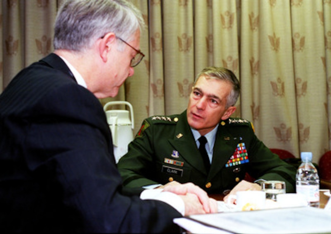 Gen. Wesley Clark, U.S. Army, supreme allied commander Europe (right) meets with Deputy Secretary of Defense John J. Hamre (left) before Hamre attends the second day of the December NATO Defense Ministerial at NATO Headquarters, Brussels, Belgium, on Dec. 18, 1998. Hamre was a last minute replacement for Secretary of Defense William Cohen at the December NATO Defense Ministerial because of the start of a joint U.S.--British bombing campaign against Iraq. The military action was taken in response to Iraq's refusal to cooperate with United Nations weapons inspectors. 