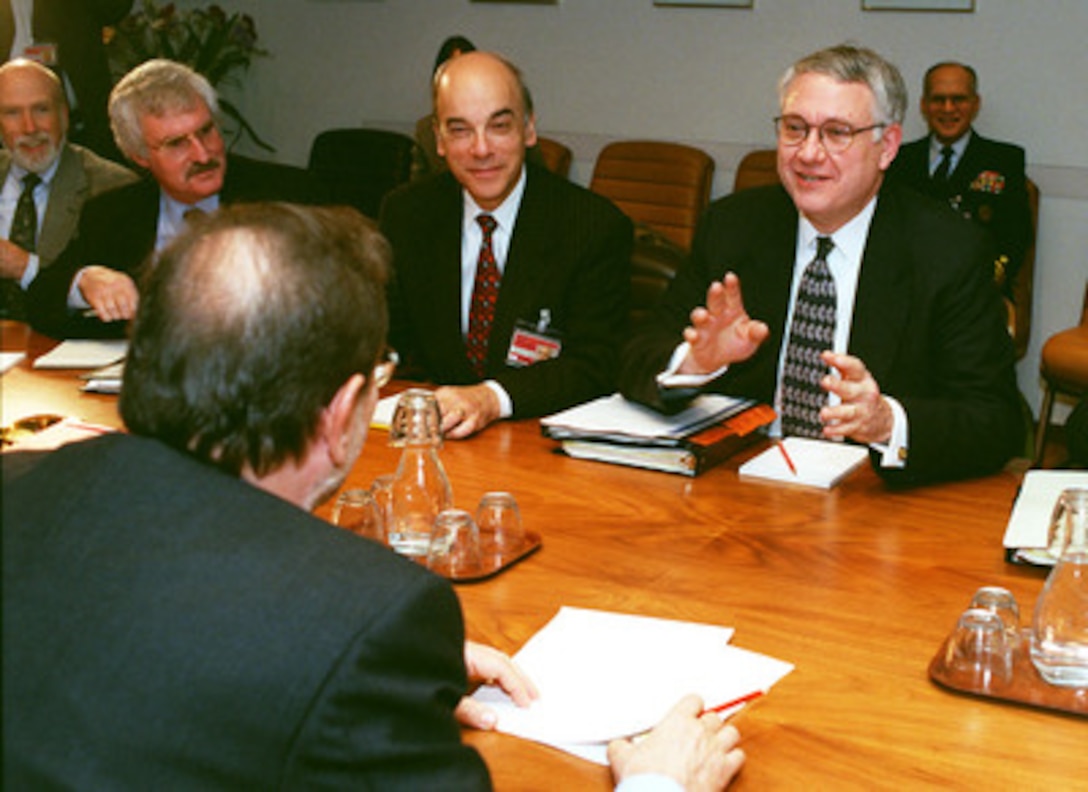 Deputy Secretary of Defense John J. Hamre (right) meets with NATO Secretary General Javier Solana (back to camera) at NATO headquarters in Brussels, Belgium, on Dec. 17, 1998. Other members of the U.S. delegation include Edward (Ted) Warner (left), assistant secretary of defense for strategy and threat reduction; Bob Hall (center), defense advisor to the U.S. Mission to NATO, and Franklin Kramer (right), assistant secretary of defense for international security affairs. Hamre replaced Secretary of Defense William Cohen at the December NATO Defense Ministerial because of the start of a joint U.S.--British bombing campaign against Iraq. The military action was taken in response to Iraq's refusal to cooperate with United Nations weapons inspectors. 
