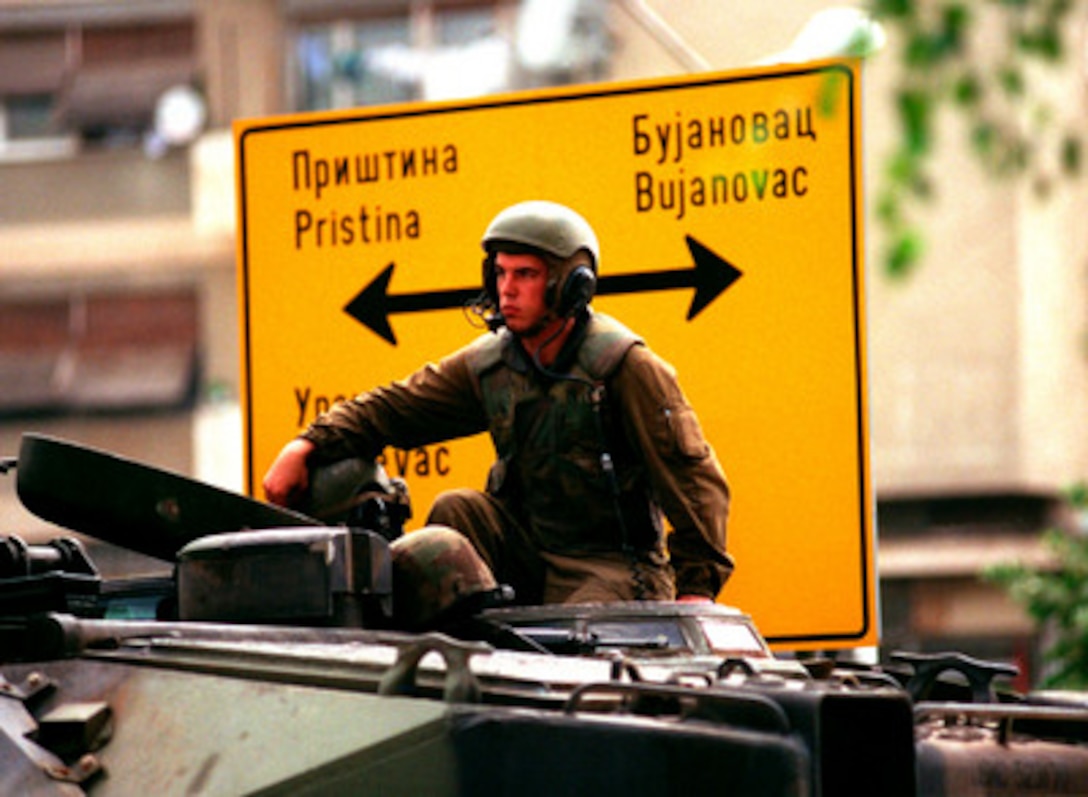 A U.S. Marine from the 2nd Amphibious Assault Vehicle Battalion sits atop his amphibious vehicle as he waits in the city of Gnjilane, Kosovo, on July 1, 1999. Elements of the 26th Marine Expeditionary Unit are deployed from ships of the USS Kearsarge Amphibious Ready Group as an enabling force for KFOR. KFOR is the NATO-led, international military force which will deploy into Kosovo on a peacekeeping mission known as Operation Joint Guardian. KFOR will ultimately consist of over 50,000 troops from more than 24 contributing nations, including NATO member-states, Partnership for Peace nations and others. 