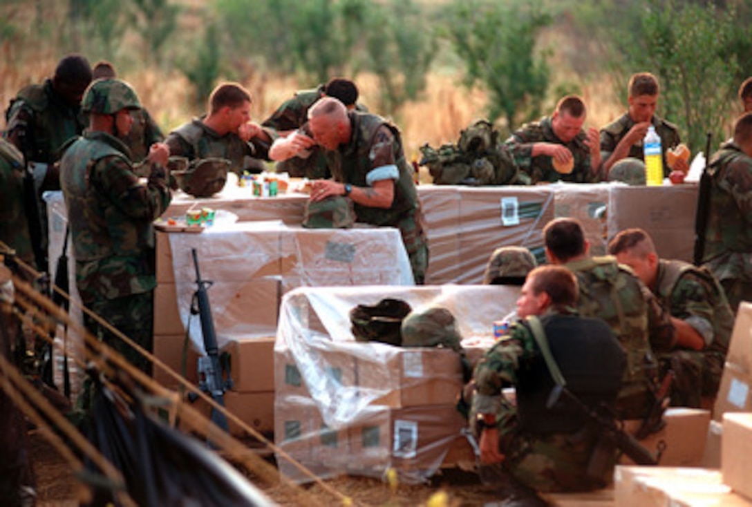 Stacked boxes become tables as U.S. Marines from the 26th Marine Expeditionary Unit eat at a field mess at Camp Monteith, near Cernica, Kosovo, on July 2, 1999. Elements of the 26th Marine Expeditionary Unit are deployed from ships of the USS Kearsarge Amphibious Ready Group as an enabling force for KFOR. KFOR is the NATO-led, international military force which will deploy into Kosovo on a peacekeeping mission known as Operation Joint Guardian. KFOR will ultimately consist of over 50,000 troops from more than 24 contributing nations, including NATO member-states, Partnership for Peace nations and others. 