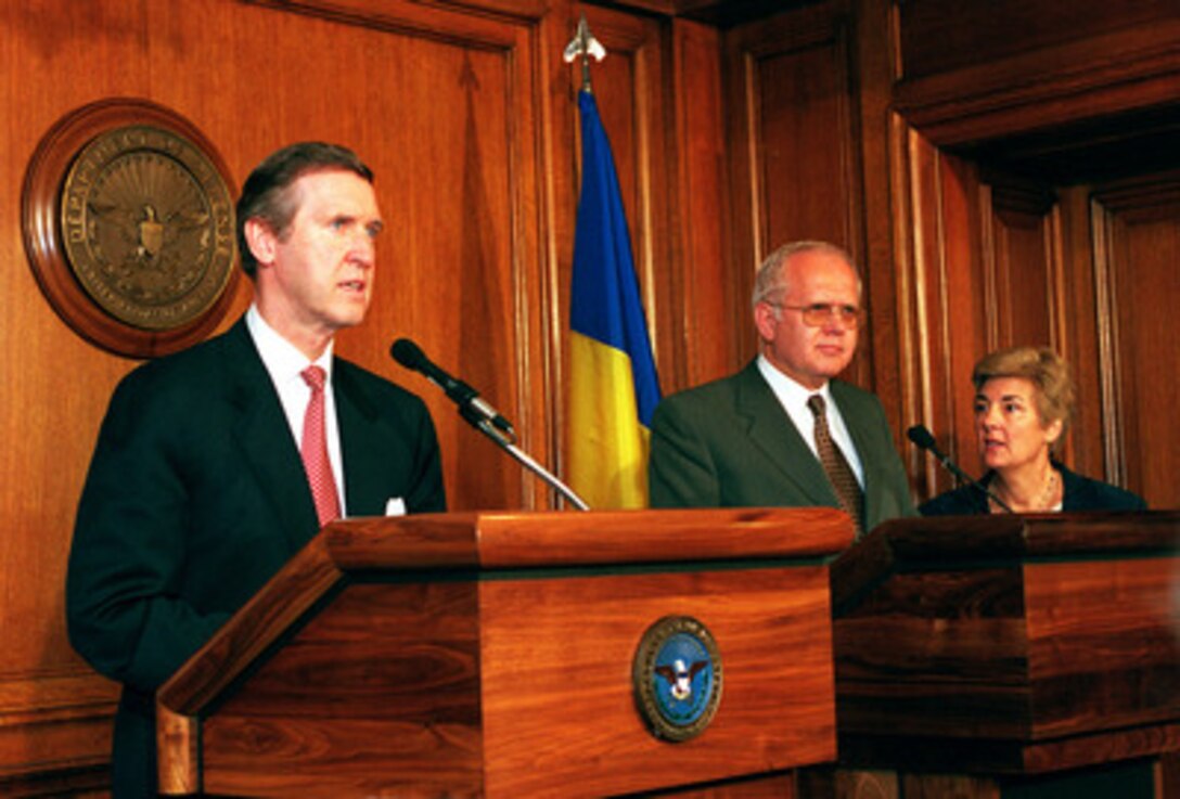 Secretary of Defense William Cohen (left) holds a press conference with visiting Romanian Minister of Defense Victor Babiuc (center) at the Pentagon on June 29, 1999. Cohen thanked Romania for granting unrestricted overflight rights for NATO aircraft during Operation Allied Force. He also praised their plans to send a military hospital and an engineering unit to participate in Operation Joint Guardian, the NATO-led, international peacekeeping force in Kosovo. 