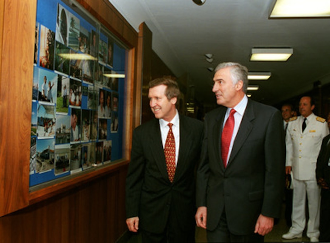 Secretary of Defense William S. Cohen (left) and Minister of Defense Jorge Dominguez (right) of Argentina stop to look at a display of photographs before a meeting in the Pentagon on June 10, 1999. The photographs were taken at the Third Defense Ministerial of the Americas, which both men attended in Cartegena, Colombia. 