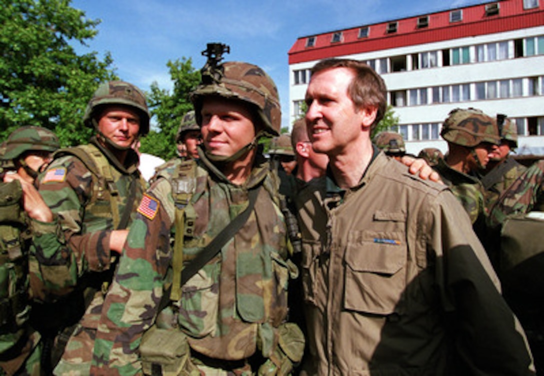 A solider from the U.S. Army's 82nd Airborne poses for a photograph with Secretary of Defense William S. Cohen at Urosevac, Kosovo, on June 19, 1999. Cohen is visiting U.S. troops deployed for KFOR which is the NATO-led, international military force in Kosovo conducting the peacekeeping mission known as Operation Joint Guardian. 