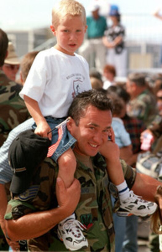 Staff Sgt. Charles Howard gives his son a piggyback ride upon returning home to Boise, Idaho, from a deployment to Trapani Air Base, Sicily, on June 30, 1999. Howard and other members of the 124th Wing were part of an all Air Guard A-10 Thunderbolt II squadron with members from Idaho, Michigan, and Massachusetts. The squadron was deployed to Sicily for NATO Operation Allied Force. Operation Allied Force was the air operation against targets in the Federal Republic of Yugoslavia. 