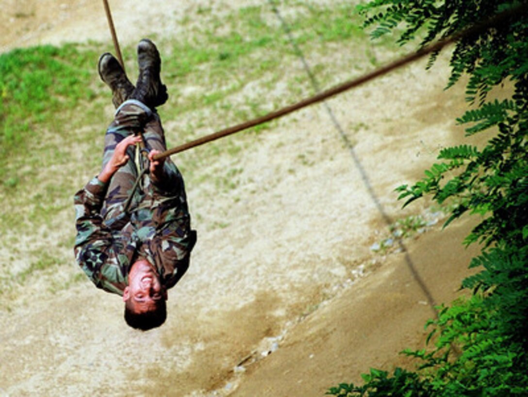 Senior Airman Frank C. Hope, U.S. Air Force, uses his hands to pull himself across a rope stretched over a ravine during Tiger Challenge '99 at U.S. Army Camp Garry Owen, Republic of Korea, on July 6, 1999. The ravine crossing is one of the 18 stages of a Republic of Korea Special Forces obstacle course during Tiger Challenge '99. Hope is an enlisted terminal attack controller or ETAC from the 604th Air Support Operations Squadron, Republic of Korea. Tiger Challenge '99 is testing Hope and 19 other competitors on their ability to perform a variety of tasks drawn directly from their mission of close air support, calling in air strikes against the enemy in close proximity to friendly forces. Hope is from Los Angeles, Calif. 