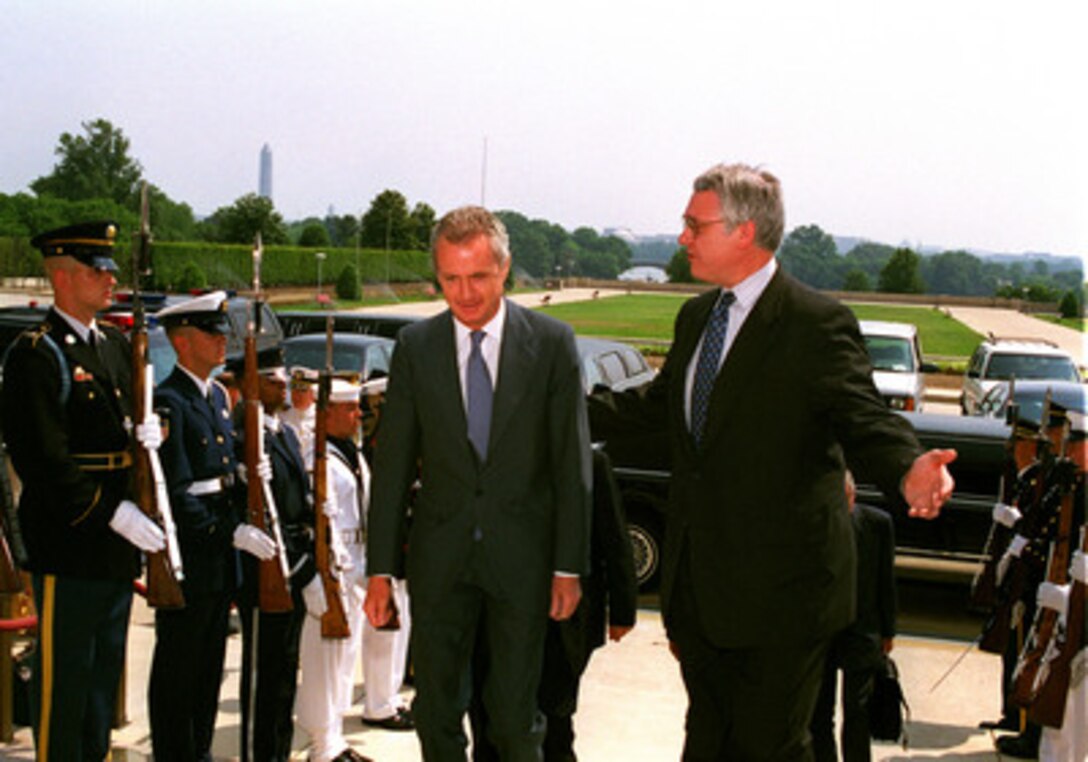 Deputy Secretary of Defense John J. Hamre (right) escorts Secretary of State for Defense Pedro Morenes Eulate (left), of the Kingdom of Spain, through an honor cordon into the Pentagon for meetings on June 7, 1999. 