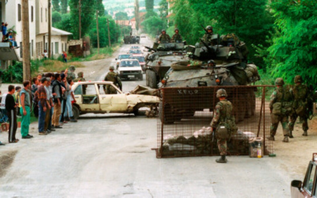 U.S. Marines from the 2nd Light Armored Reconnaissance Battalion set up a road block to check for weapons near the village of Koretin, Kosovo, on June 16, 1999. Elements of the 26th Marine Expeditionary Unit are deployed from ships of the USS Kearsarge Amphibious Ready Group as an enabling force for KFOR. KFOR is the NATO-led, international military force which will deploy into Kosovo on a peacekeeping mission known as Operation Joint Guardian. KFOR will ultimately consist of over 50,000 troops from more than 24 contributing nations, including NATO member-states, Partnership for Peace nations and others. 