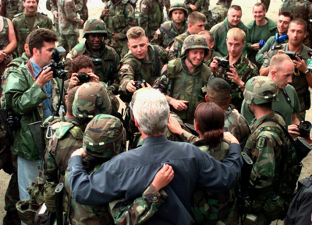 Troops crowd in as they position themselves for a photo with President Bill Clinton at Skopje, Macedonia, on June 22, 1999. Many of the troops will become part of KFOR which is the NATO-led, international military force deploying into Kosovo on a peacekeeping mission known as Operation Joint Guardian. KFOR will ultimately consist of over 50,000 troops from more than 24 contributing nations, including NATO member-states, Partnership for Peace nations and others. The president is visiting troops and refugees as he stops in Macedonia and Aviano Air Base, Italy. 