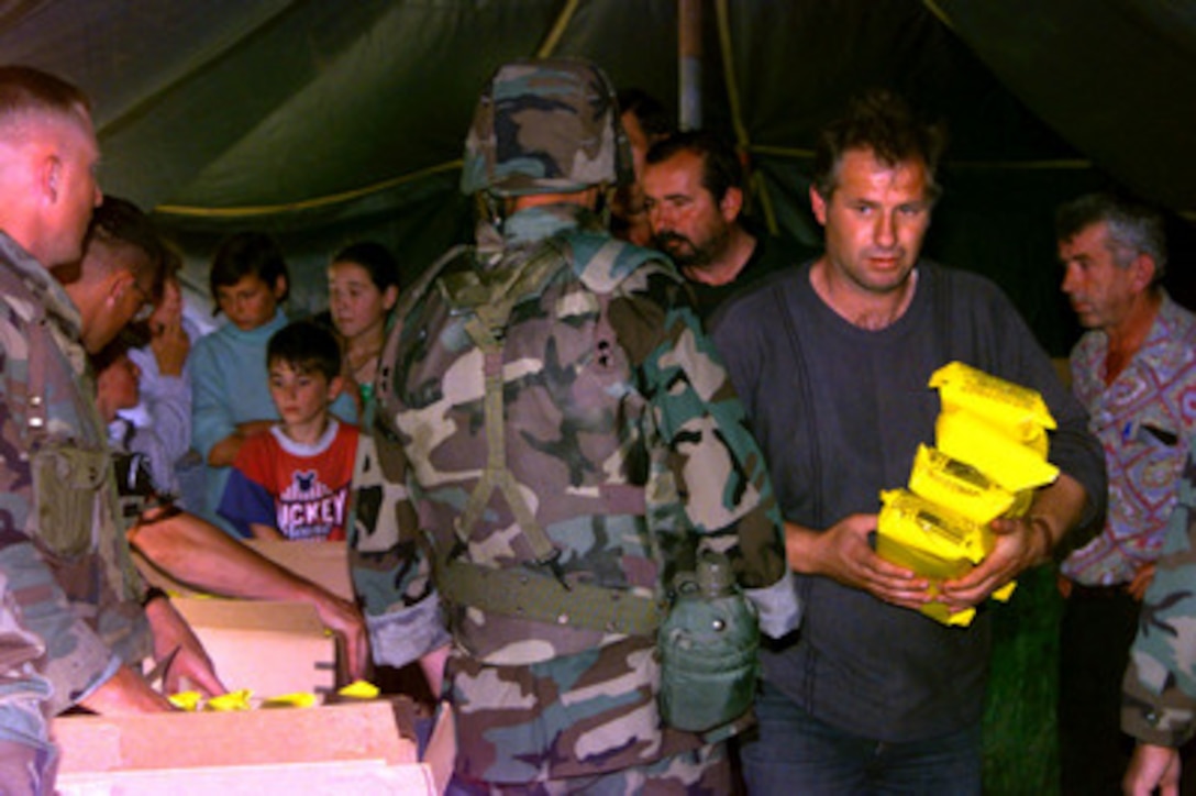 Serbian villagers receive Humanitarian Daily Rations from U.S. Marines at a temporary aid station in Kosovo on June 24, 1999. Elements of the 26th Marine Expeditionary Unit are deployed from ships of the USS Kearsarge Amphibious Ready Group as an enabling force for KFOR. KFOR is the NATO-led, international military force which will deploy into Kosovo on a peacekeeping mission known as Operation Joint Guardian. KFOR will ultimately consist of over 50,000 troops from more than 24 contributing nations, including NATO member-states, Partnership for Peace nations and others. 