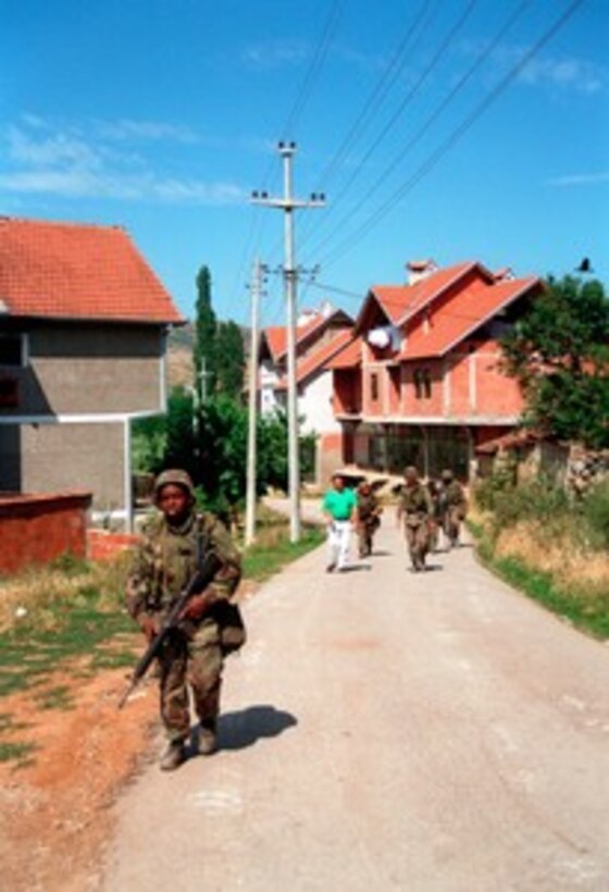 U.S. Marines patrol on foot through the streets of Zegra, Kosovo, on June 28, 1999. The Marines from Lima Battery, 3rd Battalion, 10th Marine Regiment are hitting the streets to deter looting, arson and act as a show of force in the village. Elements of the 26th Marine Expeditionary Unit are deployed from ships of the USS Kearsarge Amphibious Ready Group as an enabling force for KFOR. KFOR is the NATO-led, international military force which will deploy into Kosovo on a peacekeeping mission known as Operation Joint Guardian. KFOR will ultimately consist of over 50,000 troops from more than 24 contributing nations, including NATO member-states, Partnership for Peace nations and others. 