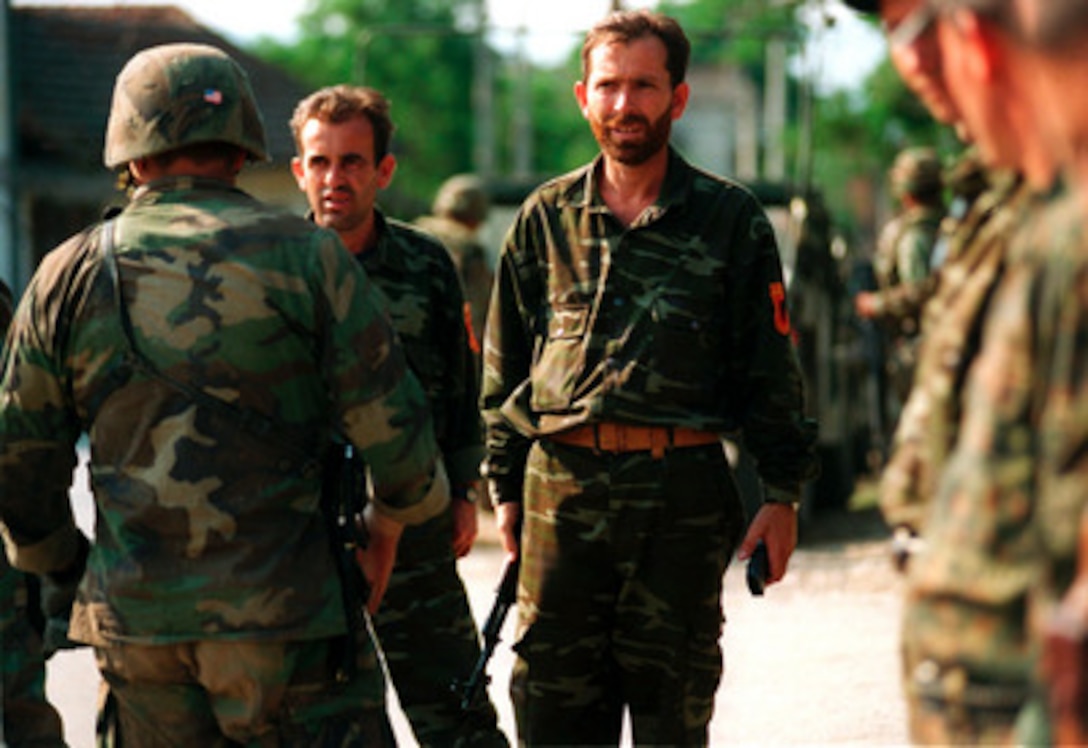 Members of the Kosovo Liberation Army stand in formation to turn over their weapons to U.S. Marines from the 26th Marine Expeditionary Unit in the village of Zegra, Kosovo, on June 30, 1999. Elements of the 26th Marine Expeditionary Unit are deployed from ships of the USS Kearsarge Amphibious Ready Group as an enabling force for KFOR. KFOR is the NATO-led, international military force which will deploy into Kosovo on a peacekeeping mission known as Operation Joint Guardian. KFOR will ultimately consist of over 50,000 troops from more than 24 contributing nations, including NATO member-states, Partnership for Peace nations and others. 