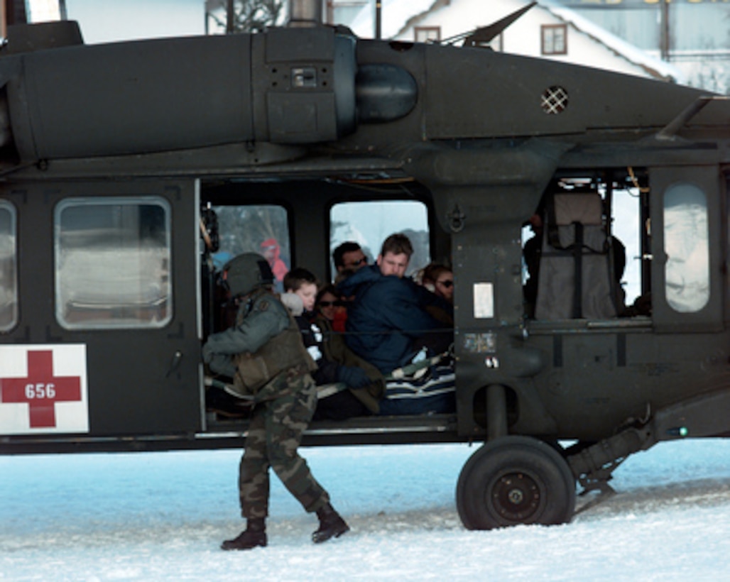 U.S. Army Sgt. Lalita Mathis checks the door of a UH-60 Blackhawk helicopter as the crew prepares to evacuate tourists stranded by an avalanche in Galtur, Austria, on Feb. 25, 1999. Blackhawks from the 5th Battalion, 158th Aviation Regiment were sent to Austria to help transport avalanche victims and stranded tourists to safety. 