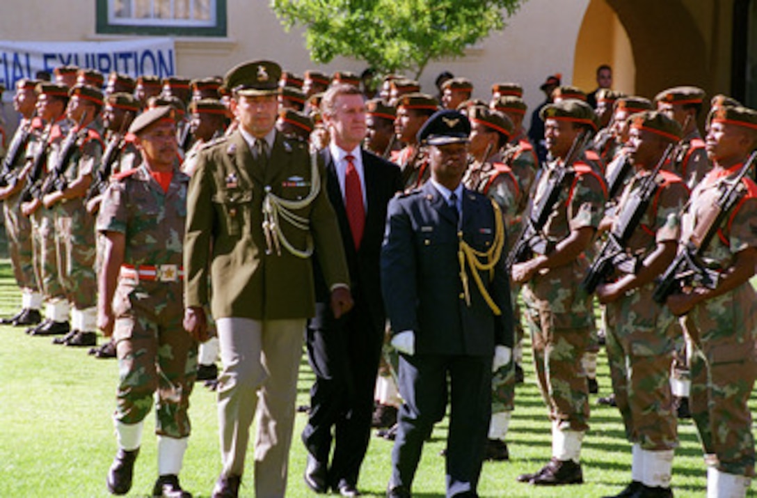 Military officers escort Secretary of Defense William S. Cohen (second from right) during an armed forces full honors welcoming ceremony at the Western Province Command (Castle), Cape Town, Republic of South Africa, on Feb. 10, 1999. 