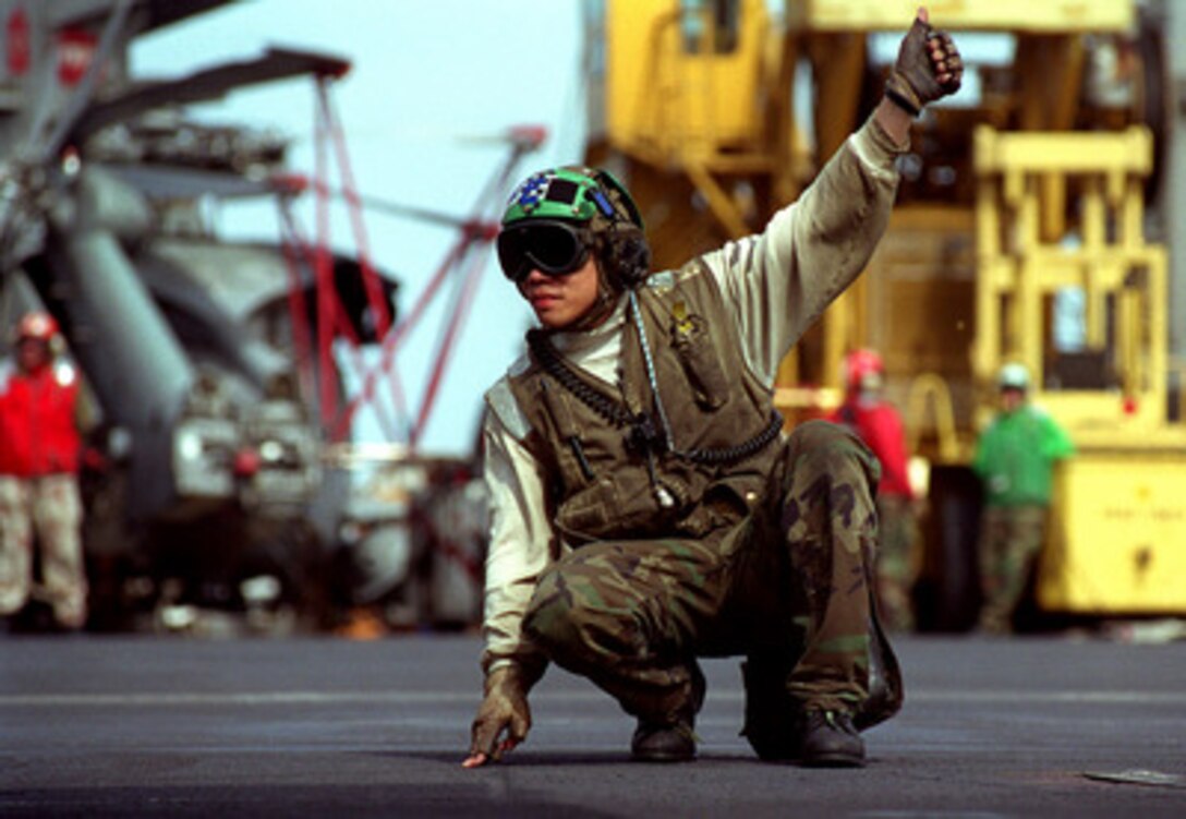 Petty Officer 3rd Class Richard Lim gives a thumbs up to acknowledge final checks on an aircraft before it catapults from the flight deck of the USS Carl Vinson (CVN-70) on Feb. 25, 1999. Vinson and its embarked Carrier Air Wing 11 are on station in the Persian Gulf in support of Operation Southern Watch, which is the U.S. and coalition enforcement of the no-fly-zone over Southern Iraq. Lim is a Navy Aviation Electrician's Mate from San Francisco, Calif. 