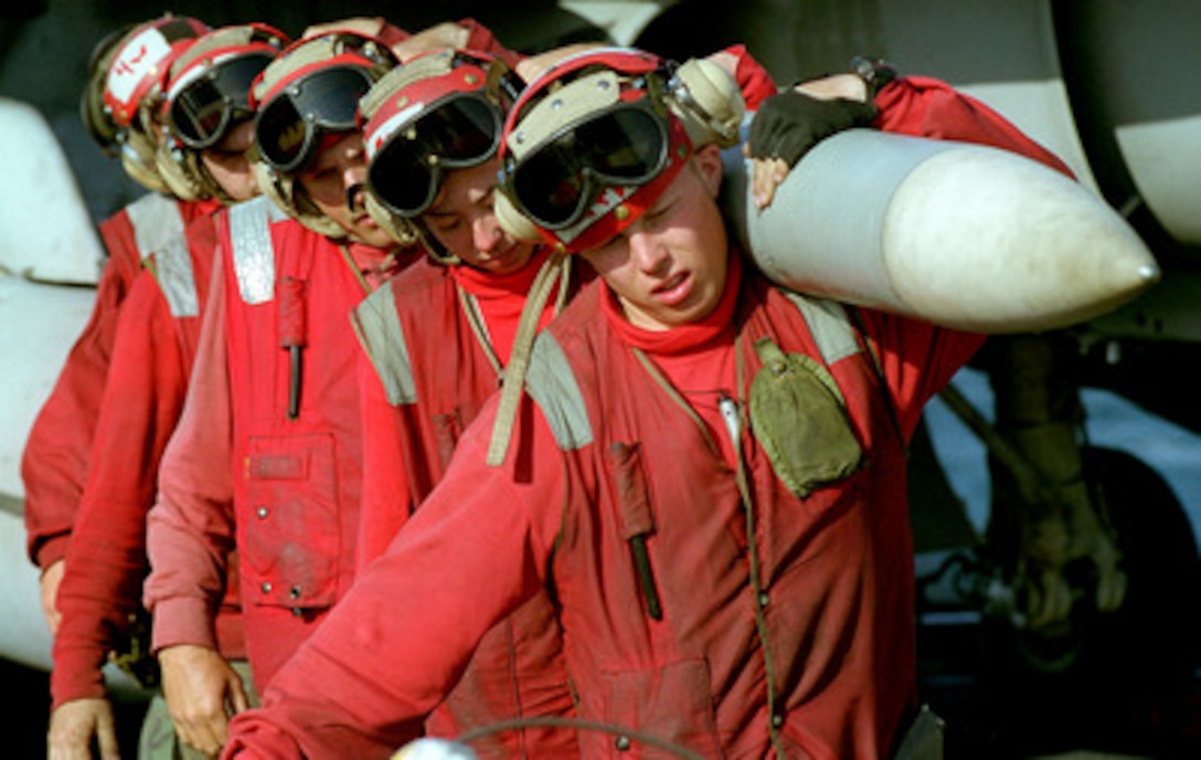 Aviation ordnancemen shoulder an AIM-7 Sparrow missile as they remove it from an F/A-18 Hornet on the flight deck of the USS Carl Vinson (CVN 70) while the aircraft carrier operates in the Persian Gulf on March 5, 1999. Vinson and its embarked Carrier Air Wing 11 are on station in the Gulf in support of Operation Southern Watch, which is the U.S. and coalition enforcement of the no-fly-zone over Southern Iraq. 