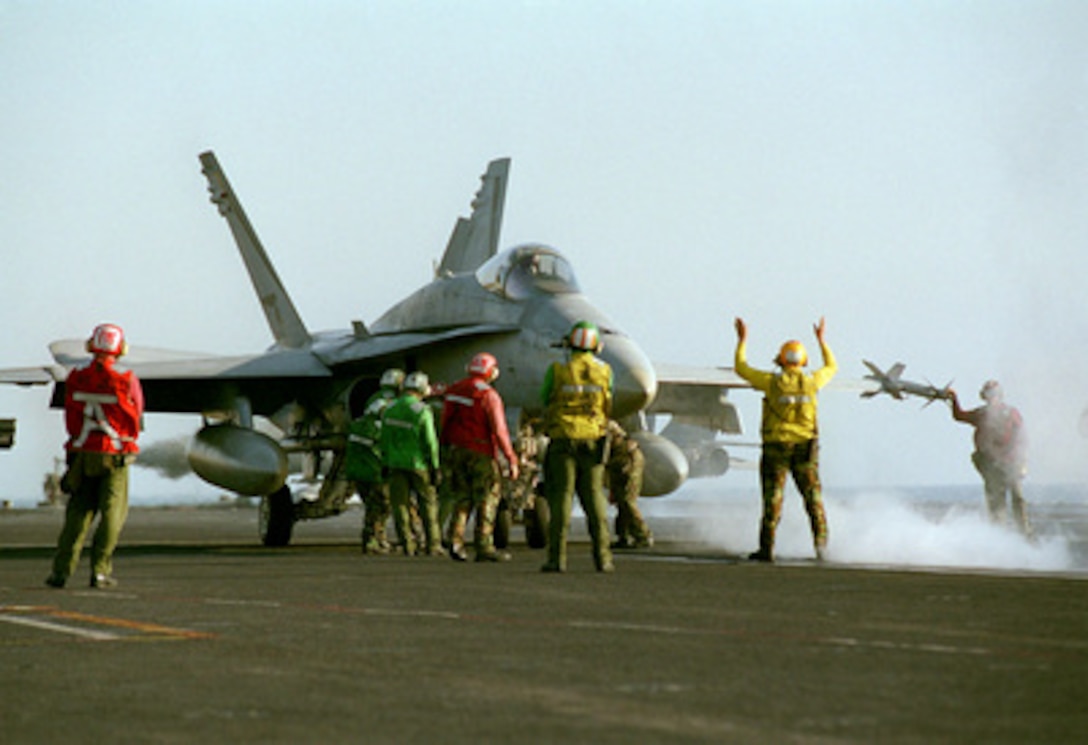 Sailors on the flight deck of the USS Carl Vinson (CVN 70) prepare an F/A-18 Hornet for launch as the aircraft carrier operates in the Persian Gulf on March 5, 1999. Vinson and its embarked Carrier Air Wing 11 are on station in the Gulf in support of Operation Southern Watch, which is the U.S. and coalition enforcement of the no-fly-zone over Southern Iraq. 