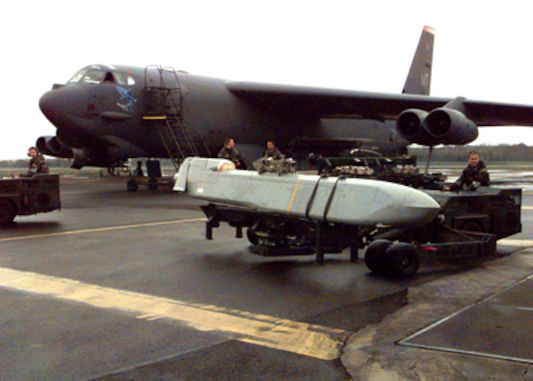 A U.S. Air Force airman transports an AGM-86C Conventional Air Launched Cruise Missile (CALCM) to a waiting a B-52H Stratofortress at RAF Fairford, United Kingdom, on March 30, 1999. The Stratofortress is being prepared for a mission in support of NATO Operation Allied Force, which is the air operation against targets in the Federal Republic of Yugoslavia. The Stratofortress and its crew are deployed from the 2nd Bomb Wing, Barksdale Air Force Base, La. 