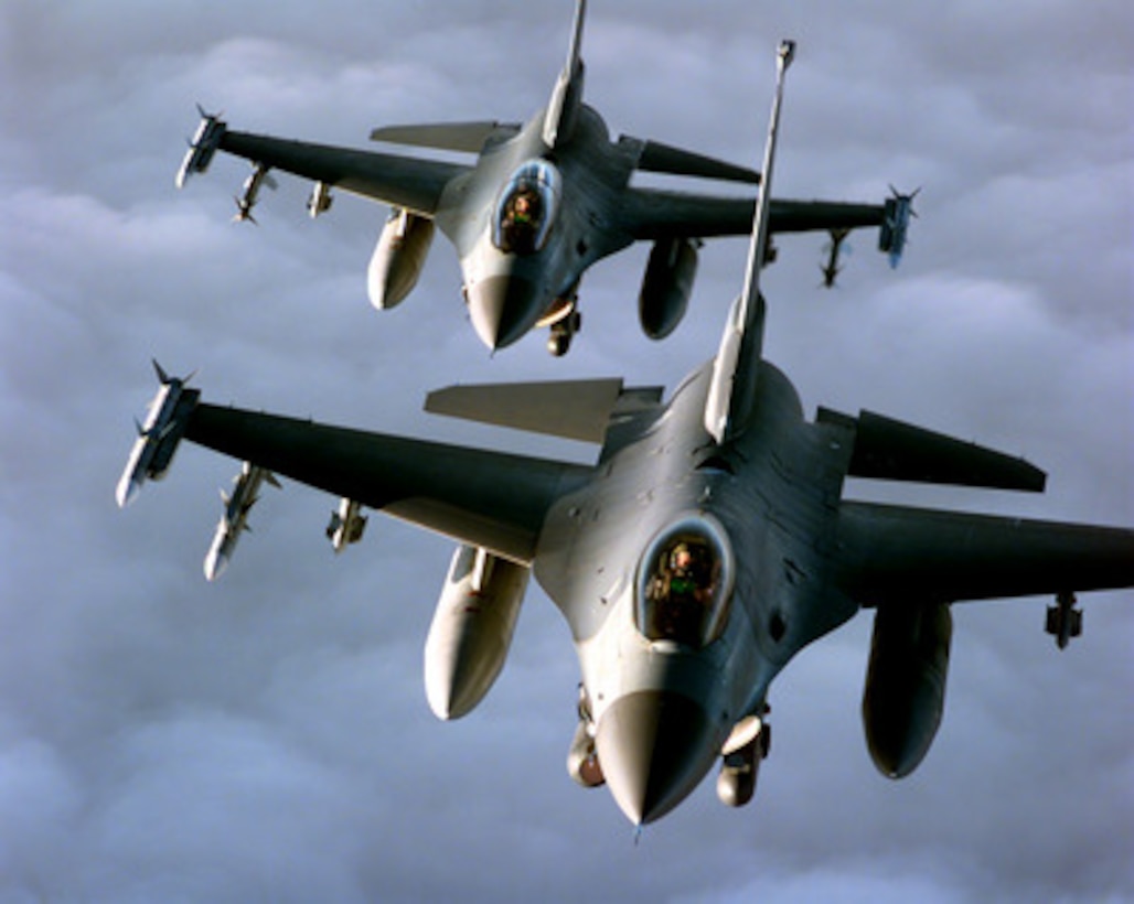 Two U.S. Air Force F-16 Fighting Falcons fly in formation during a mission in support of NATO Operation Allied Force on April 20, 1999. Operation Allied Force is the air operation against targets in the Federal Republic of Yugoslavia. The F-16's are from the 510th Fighter Squadron, Aviano Air Base, Italy, and are carrying a full air-to-air combat load to include AIM-120 Advanced Medium-Range Air-to-Air Missiles, drop tanks and an electronic jamming pod. 
