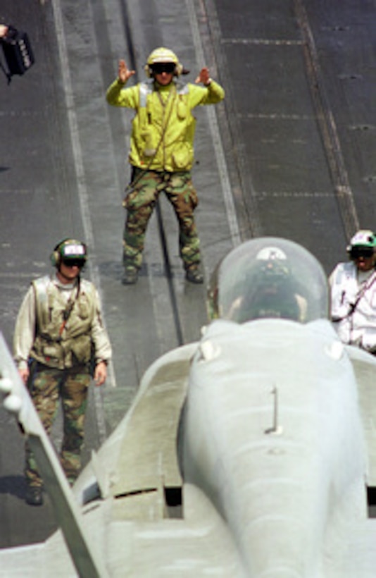 A U.S. Navy aviation boatswain's mate directs an F/A-18C Hornet to a catapult for launching from the flight deck of the USS Enterprise (CVN 65) on April 5, 1999. Enterprise and its embarked Carrier Air Wing 3 are on station in the Persian Gulf in support of Operation Southern Watch, which is the U.S. and coalition enforcement of the no-fly-zone over Southern Iraq. 