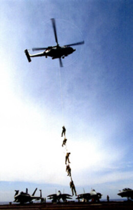 An SH-60 Seahawk helicopter lifts a string of Explosive Ordnance Disposal Technicians off the flight deck during special insertion and extraction training on board the USS Theodore Roosevelt (CVN 71) on April 21, 1999. Roosevelt and its embarked Carrier Air Wing 8 are operating in the Adriatic Sea is support of NATO Operation Allied Force which is the air operation against targets in the Federal Republic of Yugoslavia. 