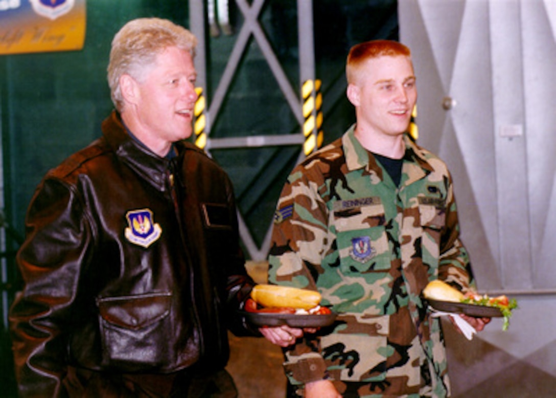 President Bill Clinton and Senior Airman Eric Reininger walk to their table during a dinner at Ramstein Air Base, Germany, on May 5, 1999. Clinton is visiting the base to personally thank the U.S. troops for their support of NATO Operation Allied Force. Operation Allied Force is the air operation against targets in the Federal Republic of Yugoslavia. Reininger is attached the 86th Transportation Squadron at Ramstein. 