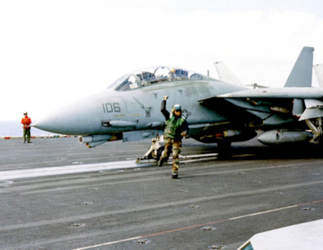 A flight deck crew member gives a thumbs up signal indicating the F-14 Tomcat fighter is ready for a catapult launch from the flight deck of the USS Theodore Roosevelt (CVN 71) for a NATO Operation Allied Force mission on May 5, 1999. Roosevelt and its embarked Carrier Air Wing 8 are operating in the Adriatic Sea in support of Operation Allied Force which is the air operation against targets in the Federal Republic of Yugoslavia. 