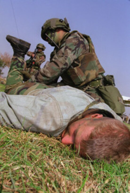 A member of the role-playing opposition force is searched by an airman from the 51st Security Forces Squadron, Osan Air Base, Korea, after he was caught infiltrating the base on Oct. 20, 1999, during Exercise Foal Eagle '99. Foal Eagle '99 is the 38th in a series of regularly scheduled rear area defense field training exercises. The annual exercise is held at a variety of locations throughout the Korean peninsula and involves some 30,000 U.S. military forces. 