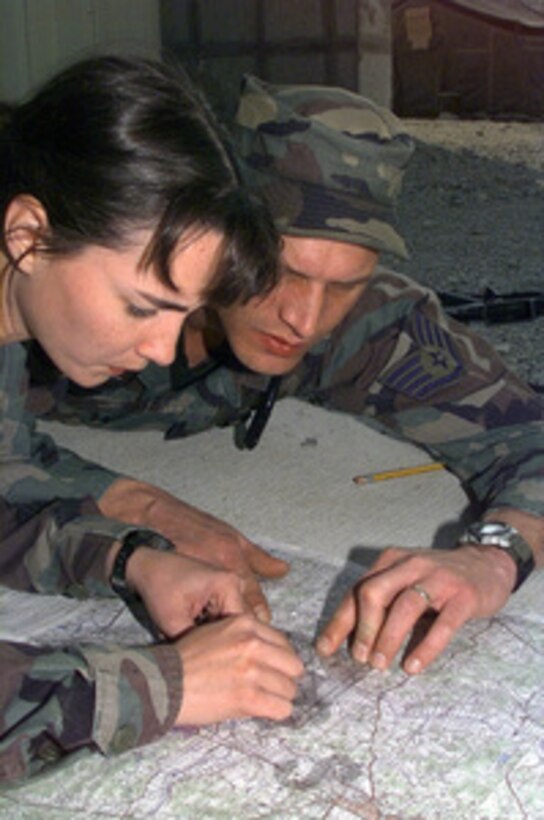 Senior Airman Bonnie Wilson (left) gets some tips from Staff Sgt. Tim Bush on the use of a land map navigator in preparation for Exercise Foal Eagle '99 at Osan Air Base, Korea, on Oct. 20, 1999. Exercise Foal Eagle '99 is the 38th in a series of regularly scheduled rear area defense field training exercises. The annual exercise is held at a variety of locations throughout the Korean peninsula and involves some 30,000 U.S. military forces. Wilson and Bush are attached to the 62nd Security Forces Squadron, McChord Air Force Base, Wash. 