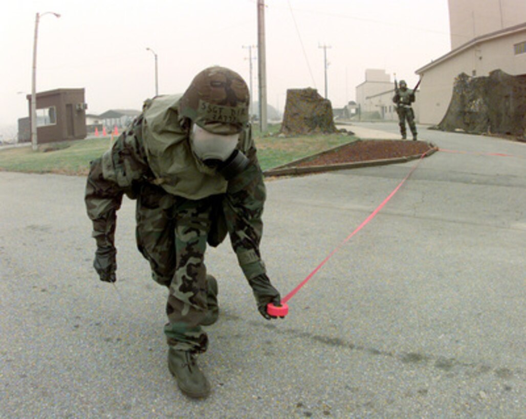 Staff Sgt. Diaz uses red tape to mark off the area around a simulated unexploded ordnance at Osan Air Base, Korea, as part of Exercise Foal Eagle '99 on Oct. 27, 1999. Exercise Foal Eagle '99 is the 38th in a series of regularly scheduled rear area defense field training exercises. The annual exercise is held at a variety of locations throughout the Korean peninsula and involves some 30,000 U.S. military forces. Diaz is attached to the 51st Maintenance Squadron at Osan. 