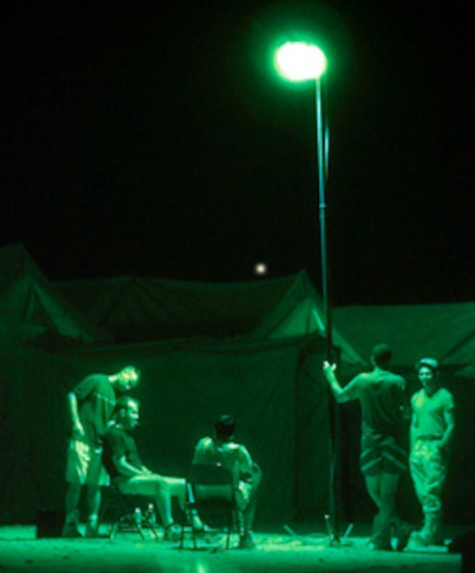 U.S. Air Force Airman 1st Class David Carpenter (left) is a combat engineer by day and a field barber by night as he cuts hair at an impromptu barber shop under the Egyptian night sky on Sept. 30, 1999. Carpenter and his customers are deployed to Egypt for Exercise Bright Star '99/00. Bright Star is a joint/combined command post and tactical field exercise in Egypt involving over 50,000 participants from 11 countries. The annual exercise is designed to improve readiness and interoperability between U.S., Egyptian and coalition forces. The green glow of the photograph is caused by the night vision adapter placed on the camera. 