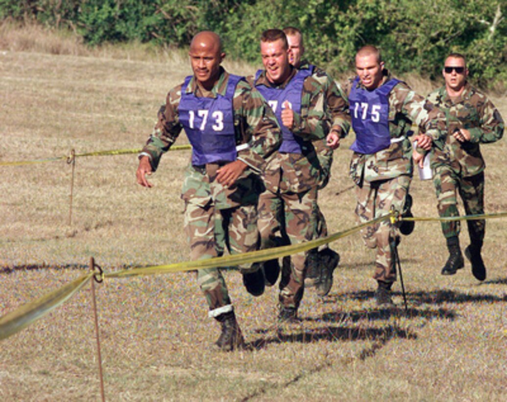 Members of the Pacific Air Forces Team push to their limits as they finish the 21 obstacle fitness challenge portion of Defender Challenge '99 at Lackland Air Force Base, Texas, on Nov. 1, 1999. Defender Challenge is an all-star competition featuring Security Forces from Air Force major commands and the Royal Air Force Regiment. Teams compete in a fitness challenge, handgun events, combat rifle, combat weapons and nighttime tactical events. 
