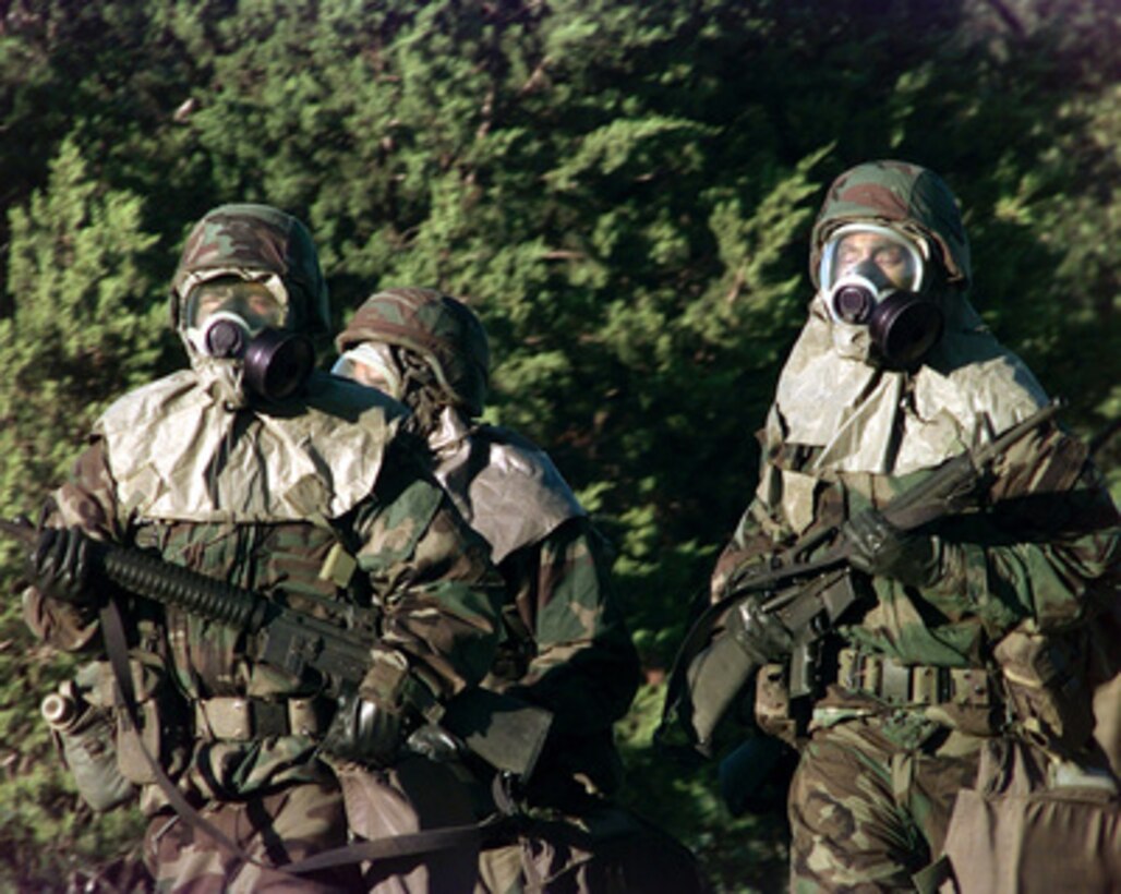 Competitors from the 11th Wing run in full chemical gear during the Combat Rifle event of Defender Challenge '99 at Lackland Air Force Base, Texas, on Nov. 3, 1999. Defender Challenge is an all-star competition featuring Security Forces from Air Force major commands and the Royal Air Force Regiment. Teams compete in a fitness challenge, handgun events, combat rifle, combat weapons and nighttime tactical events. 