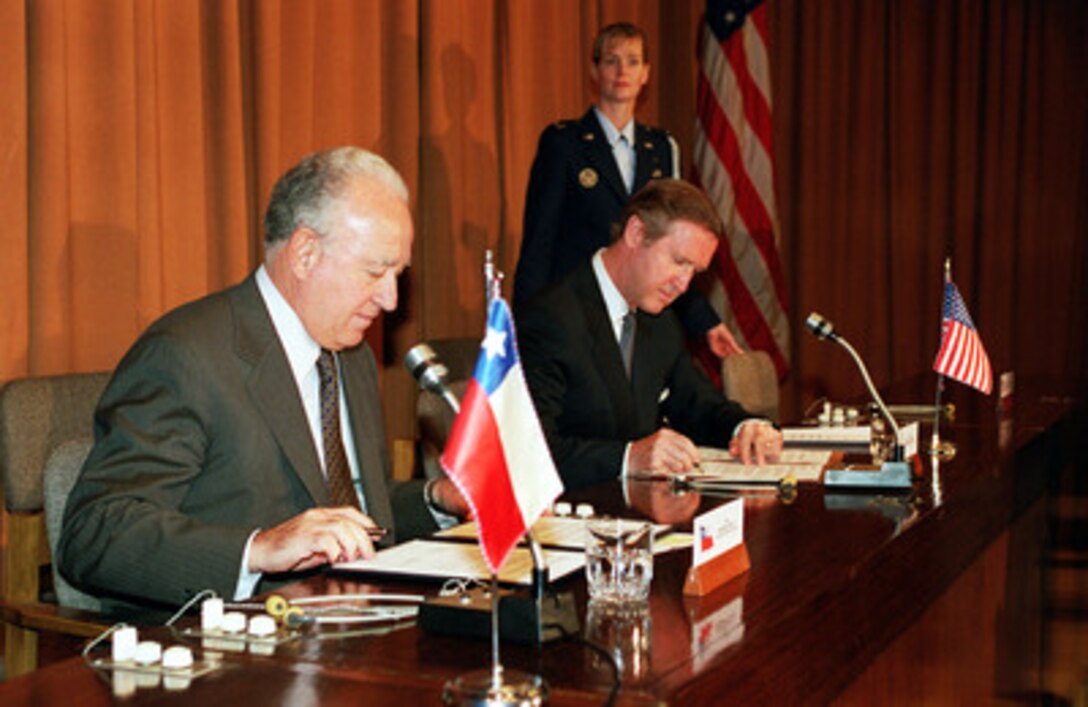 Minister of Defense Edmundo Perez Yoma (left), of the Republic of Chile, and Secretary of Defense William S. Cohen (right) sign a Joint Statement on Defense Environmental Cooperation prior to their joint press conference in Santiago, Chile on Nov. 16, 1999. Cohen is in Santiago to meet with defense officials and discuss issues of interest to both nations. 