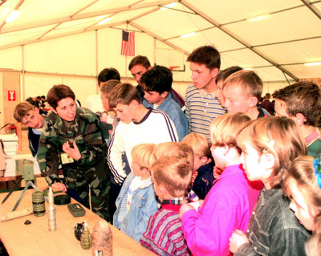 Children from the town of Staric, Bosnia and Herzegovina, listen to a translator explain the hazards of anti-personnel mines during Kids' Day activities at Camp Demi, Bosnia and Herzegovina, on Nov. 6, 1999. 
