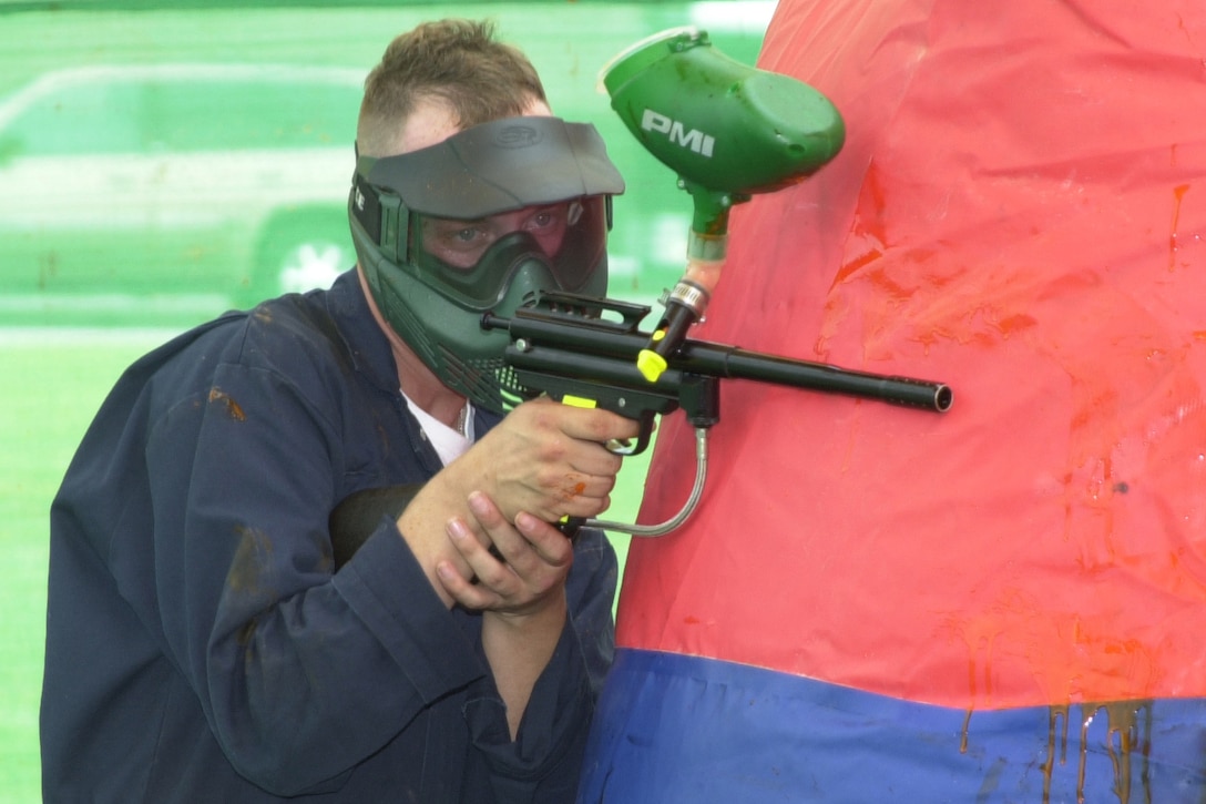 MARINE CORPS BASE CAMP LEJEUNE, N.C. - Pfc. Billy Toal takes cover while returning fire in a game of paintball here July 31. Service and family members alike can participate in this game at Coastal Paintball located on Parachute Tower Road. The store offers general repairs to paintball guns, replacement tanks for the guns and tank refills. It also offers paintball guns for sale and rent. Toal is a student at the Marine Corps Engineer School on Camp Johnson. (Official U.S. Marine Corps photo by Lance Cpl. Brandon R. Holgersen)