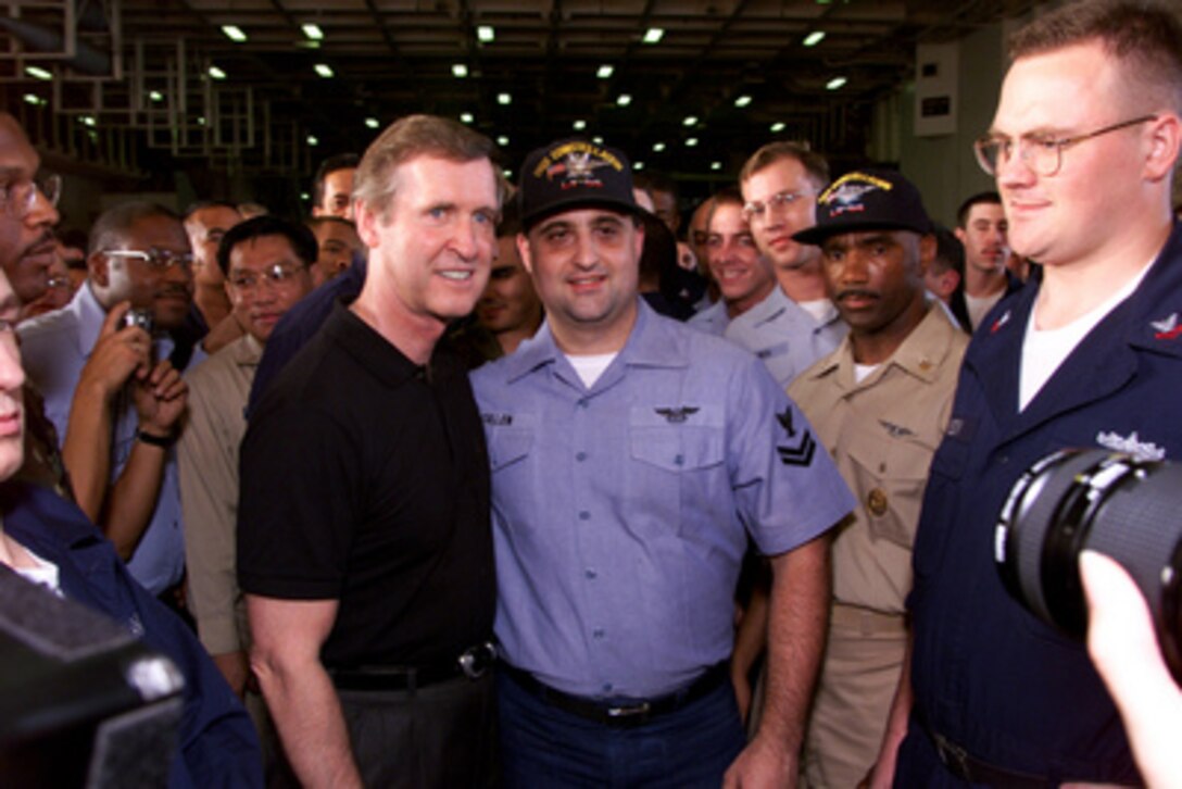 Secretary of Defense William S. Cohen (left) poses for photos with crew members of the aircraft carrier USS Constellation (CV 64) as the ship operates in the Persian Gulf on Oct. 23, 1999. Cohen is visiting the ship as part of a diplomatic tour of the Persian Gulf and Middle East. 
