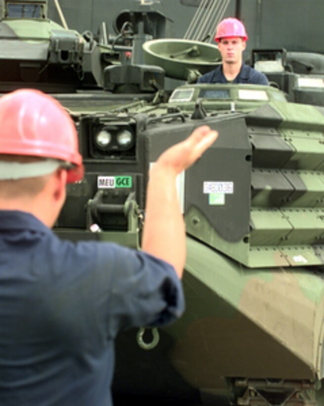 The driver of a U.S. Marine Corps Amphibious Assault Vehicle is guided as the tracked vehicle is off loaded from the Maritime Prepositioning Ship MV 1st Lt. Jack Lummus in Gladstone, Australia, on Sept. 30, 1999. The assault vehicle will be used in Exercise Crocodile '99 which is a combined U.S. and Australian military training exercise being conducted at the Shoalwater Bay Training Area in Queensland, Australia. 