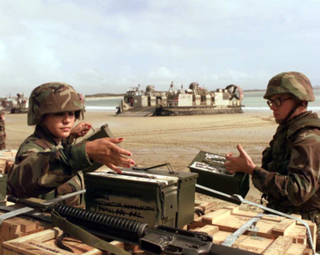 U.S. Marine Pfc. Reuschel Ortiz (left) directs the distribution of ammunition at Freshwater Beach, Australia, during amphibious assault landing operations of Exercise Crocodile '99 on Oct. 1, 1999. Exercise Crocodile '99 is a combined U.S. and Australian military training exercise being conducted at the Shoalwater Bay Training Area in Queensland, Australia. 
