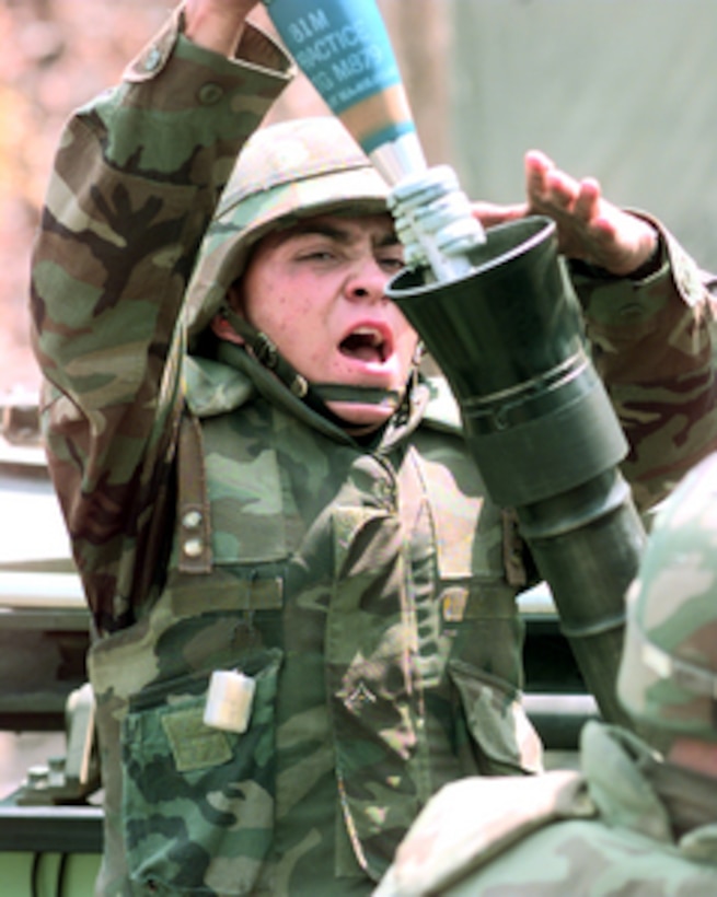 U.S. Marine Amphibious Assault Vehicle gunner Lance Cpl. Francisco Gonzalez loads a 81 mm mortar round as the call is made for the 3rd Light Armored Reconnaissance Company to drop ordnance on target at the Shoalwater Bay Area Training Area in Queensland, Australia, on Oct. 14, 1999. The Marines are taking part in Exercise Crocodile '99, a combined U.S. and Australian military training exercise being conducted at the Shoalwater Bay Training Area. 