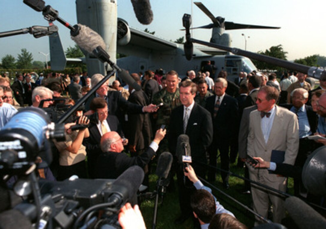 Secretary of Defense William S. Cohen talks with reporters about the MV-22 Osprey aircraft at the Pentagon on Sept. 8, 1999. The Bell Boeing Osprey is at the Pentagon to demonstrate its capabilities before an audience of Department of Defense officials, members of Congress, and news reporters. The Osprey is the first operational aircraft to utilize tiltrotor technology. Taking off like a helicopter, the Osprey's engines then rotate forward 90 degrees to create a conventional aircraft configuration permitting high-speed, high-altitude, fuel-efficient flight. For landing, the engines again rotate to the vertical allowing the aircraft to land in helicopter fashion. The U.S. Marine Corps plans to acquire 360 Ospreys by the year 2013, with the U.S. Navy and Air Force planning to purchase about 50 each. The Marine version can transport 24 combat-equipped personnel or a 15,000-pound external load. 