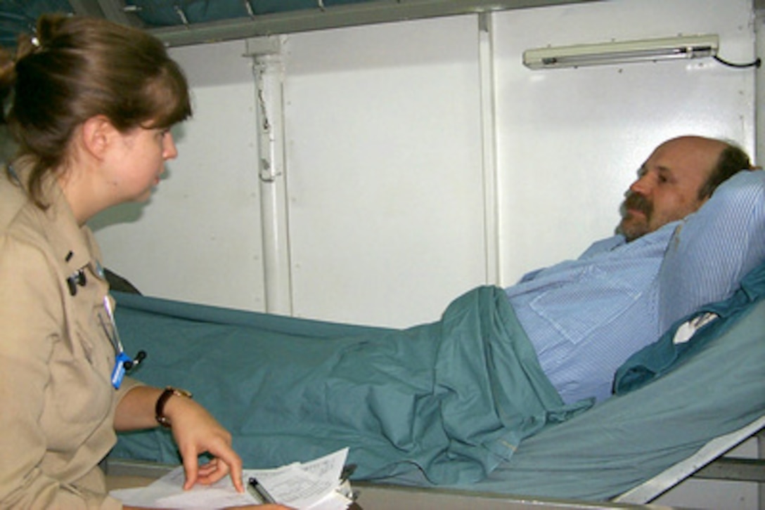 David Lytle (right) talks to Lt. j.g. Santana in the Medical Department of the USS John F. Kennedy (CV 67) after being rescued at sea by a helicopter from the aircraft carrier on Sept. 15, 1999. Lytle was one of eight crew members rescued after abandoning their capsized ocean tug Gulf Majesty in heavy seas off the coast of Florida during Hurricane Floyd. The USS John F. Kennedy responded to their distress call some 150 miles from the tugs reported location. The aircraft carrier had been at sea less than a day after leaving the ship's home port of Mayport, Fla., to ride out Hurricane Floyd. 