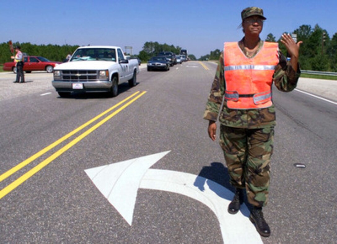 North Carolina Army National Guard Pfc. Latisha Smith helps state police officers direct traffic on Highway 701 at the Interstate 40 interchange northeast of Fayetteville, N.C., on Sept. 17, 1999. Smith has been called on state active duty for Hurricane Floyd relief efforts. Smith is attached to the 30th Infantry Brigade, North Carolina Army National Guard, from Mount Olive, N.C. 