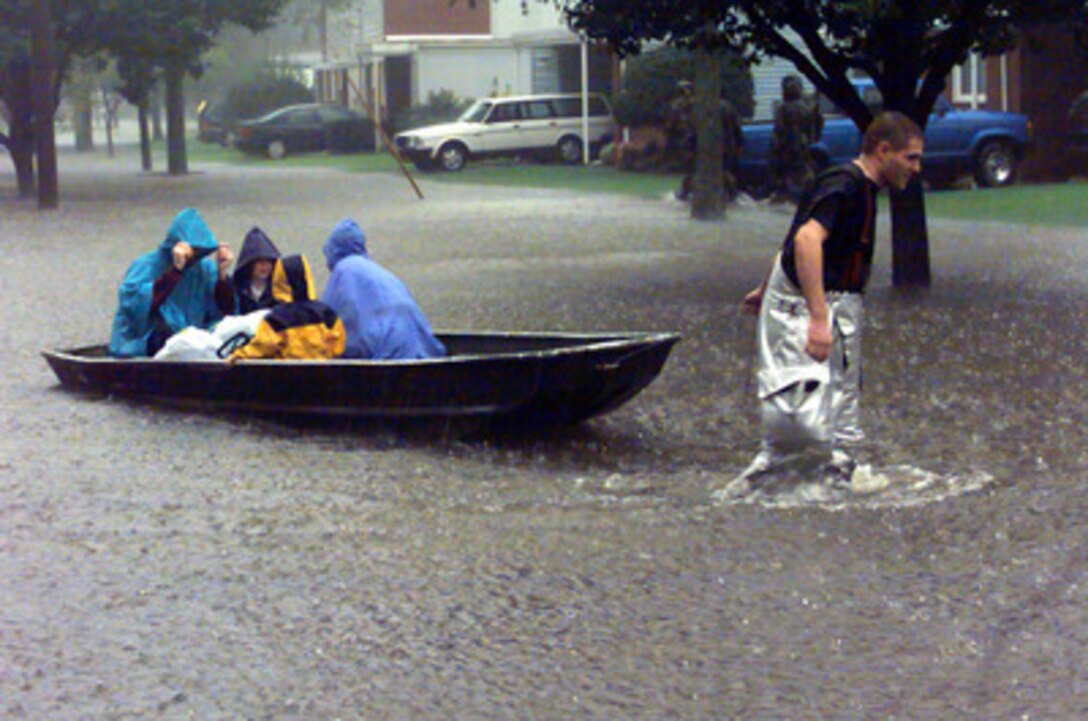 A Langley Air Force Base, Va., firefighter pulls a boat loaded with evacuees through the flood waters of Hurricane Floyd on Sept. 16, 1999. More than 200 residents of base housing had to be evacuated from their homes when a nearby reservoir overflowed. 