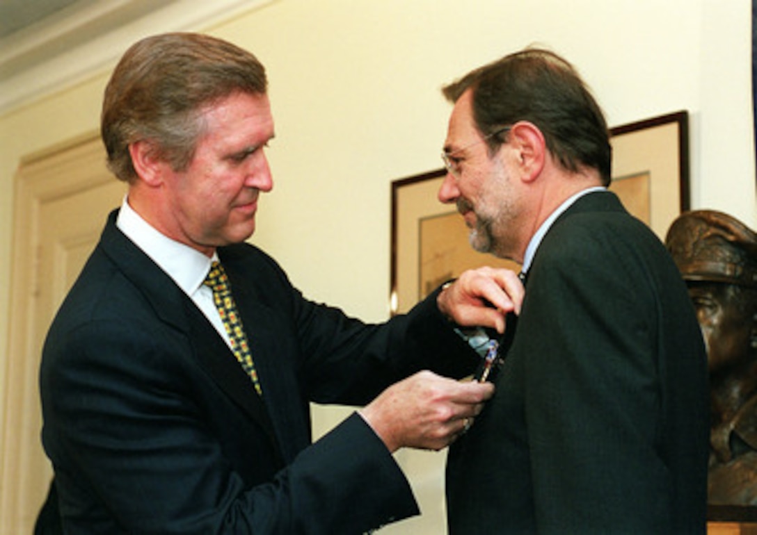 Secretary of Defense William S. Cohen (left) pins the Department of Defense Medal for Distinguished Public Service on the lapel of NATO Secretary General Javier Solana (right), of Spain, during a Sept. 23, 1999, Pentagon ceremony. Cohen is honoring the outgoing secretary general for his leadership of NATO over the past four years. 