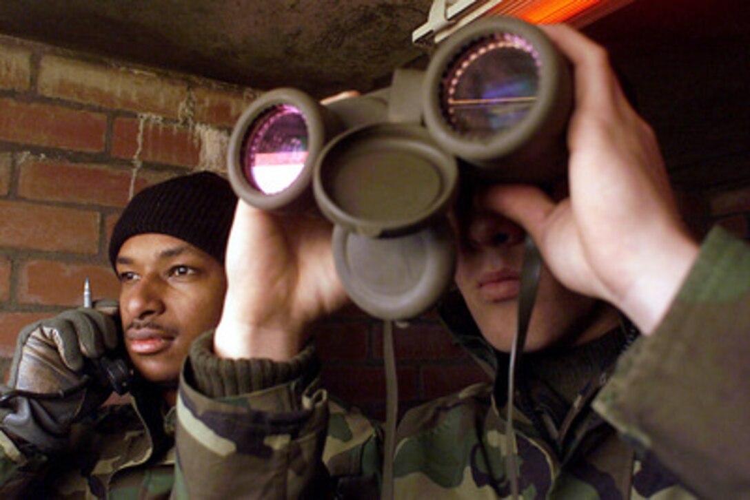 U.S. Marine Cpl. Timothy W. Stafford (right) watches down range as Cpl. Patrick W. Villette (left) confirms the location of a U.S. Navy ship during the naval gunfire certification of the Eisenhower Battlegroup at Cape Wrath Range, Scotland, on March 2, 2000. This is the first time the range at Cape Wrath has been used to certify U.S. Navy ships in naval gunfire support. Marines of the 2nd Marine Division and sailors of the Expeditionary Warfare Training Group, Atlantic, worked with the United Kingdom's 148th Commando Forward Observation Battery, Royal Artillery, at Cape Wrath to certify the ships. Stafford, from Rockport, Ind., and Villette, from Brooklyn, N.Y., are attached to Headquarters 5th Battalion, 10th Marines. 