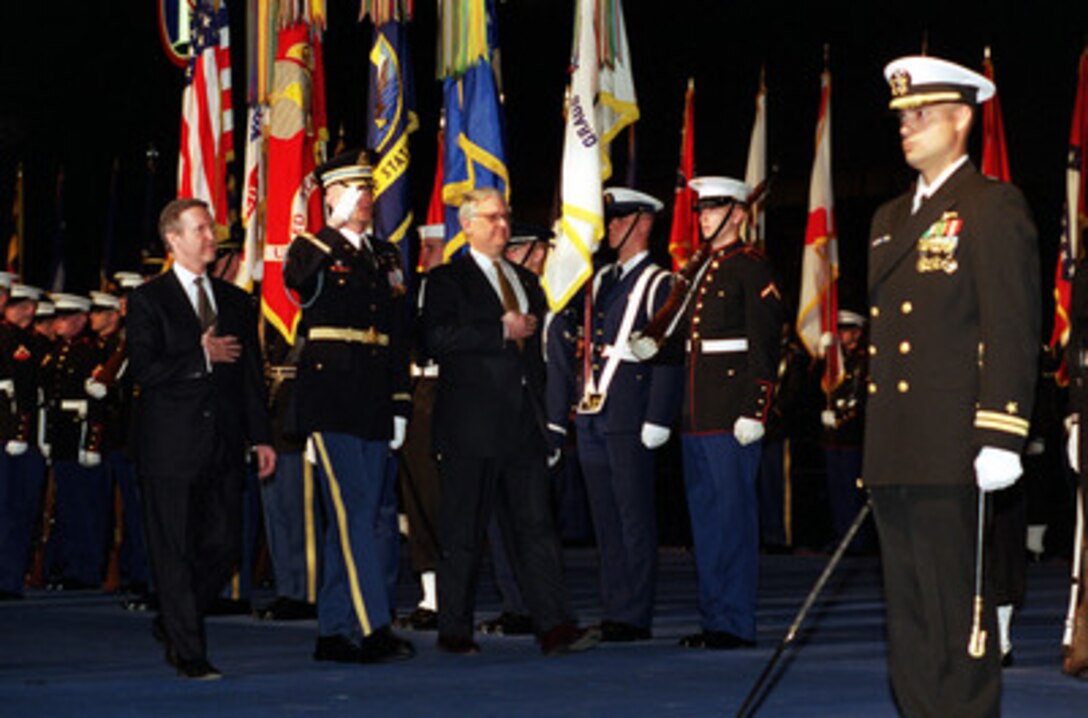 Secretary of Defense William S. Cohen (left) and outgoing Deputy Secretary of Defense John J. Hamre (right) are escorted by Commander of Troops Lt. Col. Charles Sniffin (center), U.S. Army, as Hamre inspects the troops during an armed forces review and award ceremony in his honor at Conmy Hall, Fort Myer, Va., on March 30, 2000. Hamre has served as the 26th Deputy Secretary of Defense since July 29, 1997. 