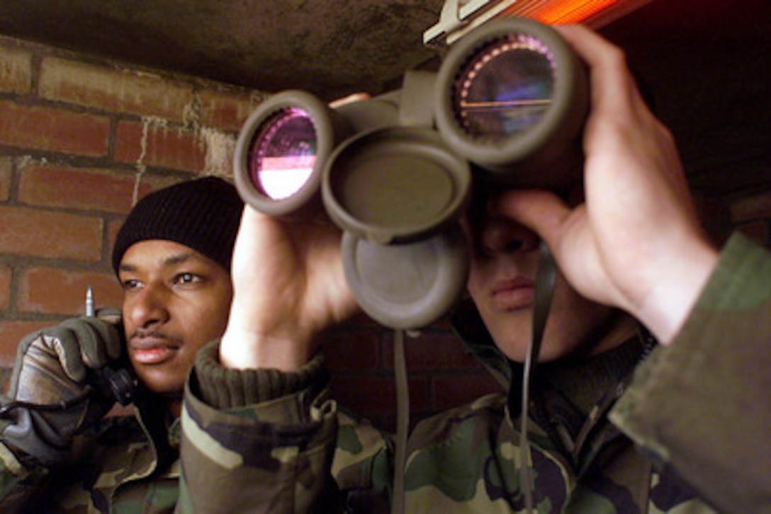 U.S. Marine Cpl. Timothy W. Stafford (right) watches down range as Cpl. Patrick W. Villette (left) confirms the location of a U.S. Navy ship during the naval gunfire certification of the Eisenhower Battlegroup at Cape Wrath Range, Scotland, on March 2, 2000. This is the first time the range at Cape Wrath has been used to certify U.S. Navy ships in naval gunfire support. Marines of the 2nd Marine Division and sailors of the Expeditionary Warfare Training Group, Atlantic, worked with the United Kingdom's 148th Commando Forward Observation Battery, Royal Artillery, at Cape Wrath to certify the ships. Stafford, from Rockport, Ind., and Villette, from Brooklyn, N.Y., are attached to Headquarters 5th Battalion, 10th Marines. 