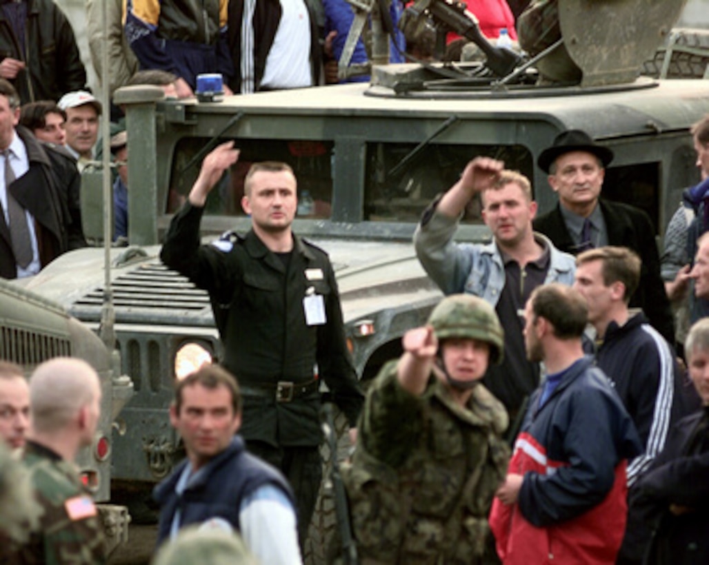 Soldiers from the 709th Military Police Battalion in Humvee's make their way through a hostile crowd in Sevce, Kosovo on April 4, 2000. Several hundred Kosovar Serbs were blocking the road to protest the arrest earlier in the day of a local who was suspected of possesing munitions. 