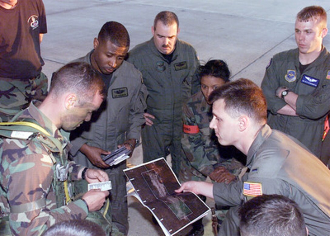 Capt. Ray Robinsion, Aircraft Commander, and 1st Lt. Mike Arndt, a Navigator from the 6th Airlift Squadron, give a final briefing to the Jumpmasters of the 82nd Airborne. The briefing gives the Jumpmasters the latest conditions for their mission to be inserted onto the drop zone on Ft Polk, La. The exercise, called Large Package Week, on April 5, 2000, involves the airdropping of 1200 paratroopers from the 82nd Airborne and their heavy equipment onto the drop zone. Large Package Week is a quarterly training exercise designed to build cohesiveness between the 82nd Airborne and Air Mobility Command units. The briefing took place at Pope Air Force Base, N.C. 